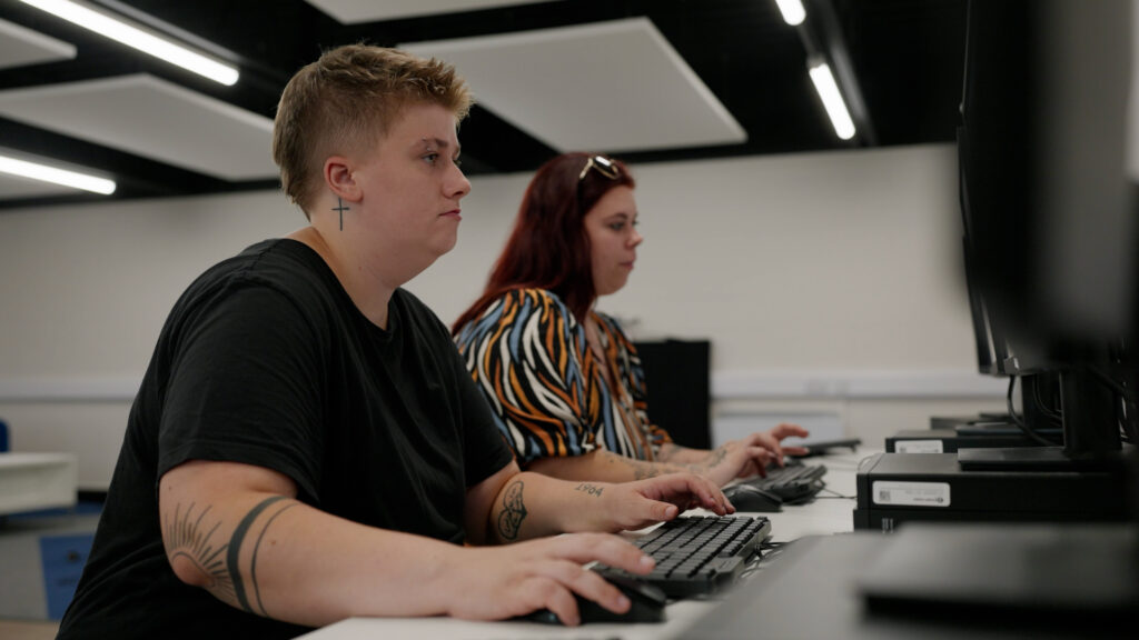 Jed, an Inspire student, sits at a computer in the Youth Hub.